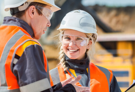 Young woman at a mine site talking to a colleague